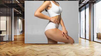 Close up shot of unrecognizable fit woman in lingerie isolated on white background. Torso of slim attractive female with flat belly in white underwear. Copy space for text. Wall mural